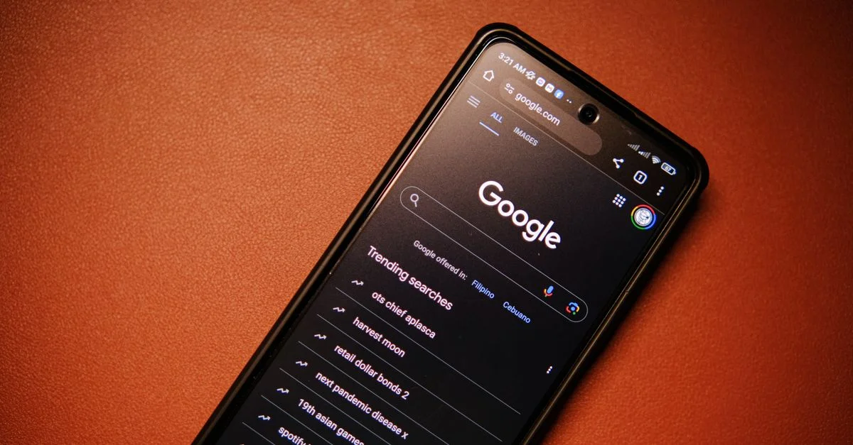 Un smartphone affichant les tendances de recherche Google sur une table la nuit.